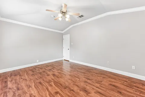 a view of an empty room with wooden floor