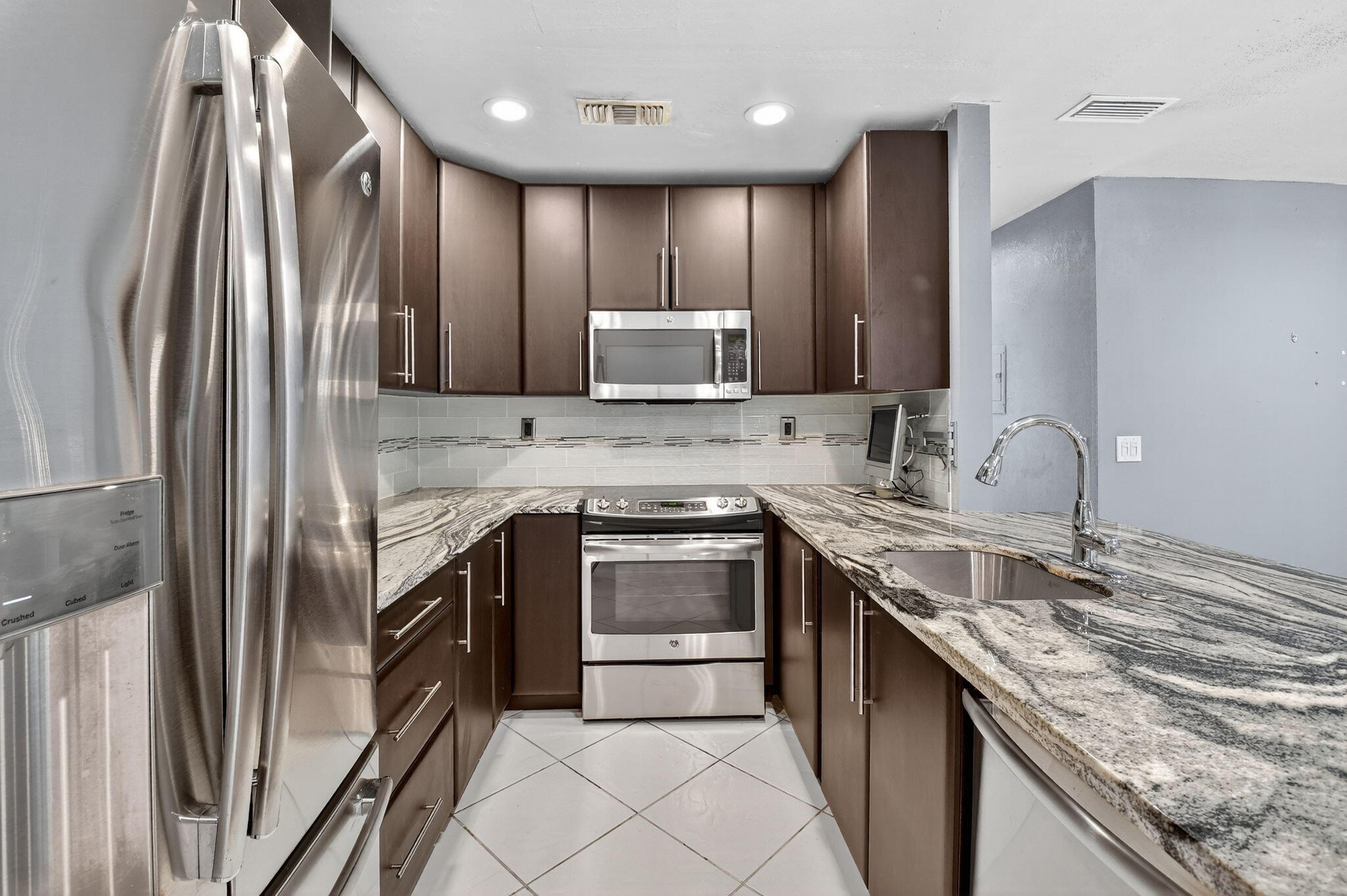624 Flanders North Delray Beach, FL 33484 - Photo 9 of 44 a kitchen with stainless steel appliances granite countertop a sink stove and refrigerator