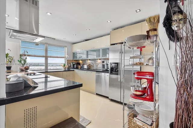 a large kitchen with stainless steel appliances a sink and cabinets