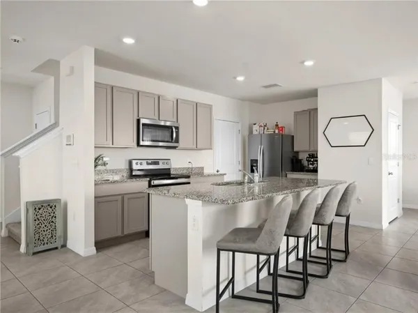 a kitchen with microwave a refrigerator and furniture