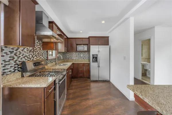 a kitchen with stainless steel appliances granite countertop a sink stove and refrigerator
