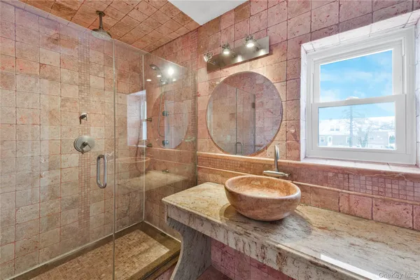 a bathroom with a granite countertop sink a mirror and a shower