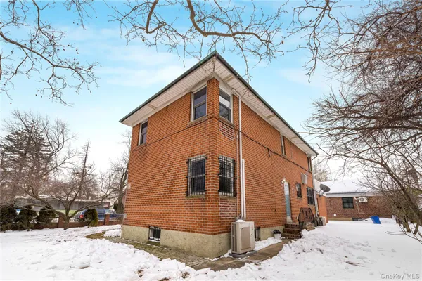 a front view of a house with a yard covered in snow