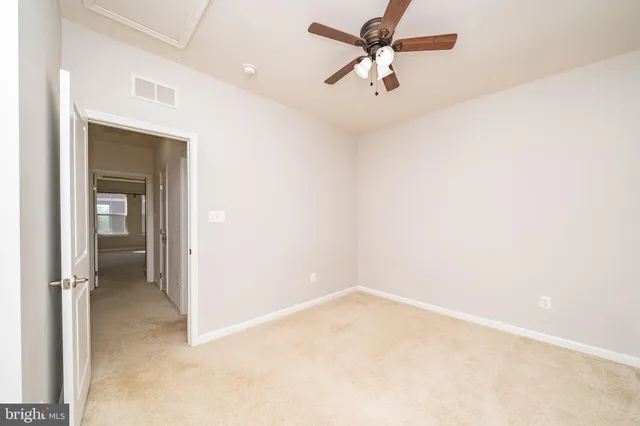 an empty room with a ceiling fan and a window