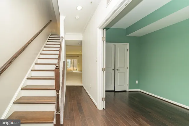 a view of a hallway with wooden floor and entryway