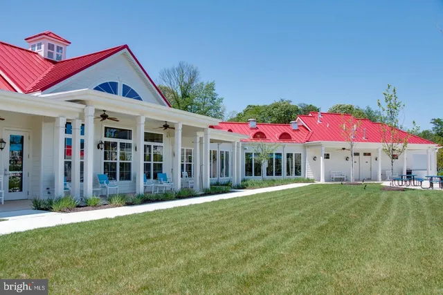 a view of swimming pool with outdoor seating and trees in the background