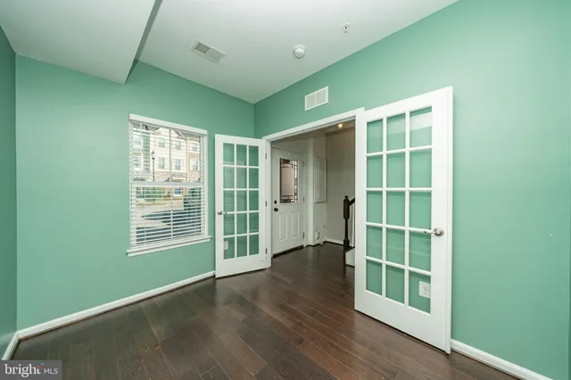 an empty room with wooden floor and windows
