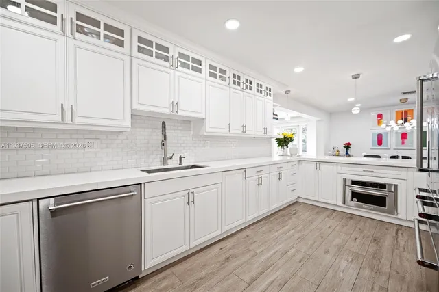 a kitchen with cabinets wooden floor and a sink