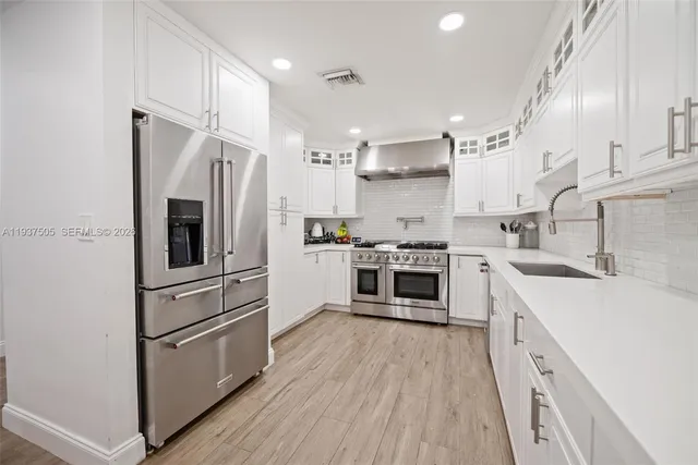a kitchen with stainless steel appliances a refrigerator sink and cabinets