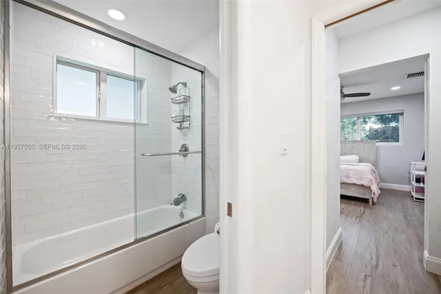 a bathroom with a toilet tub and shower