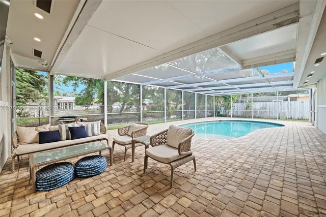a living room with patio furniture and a floor to ceiling window