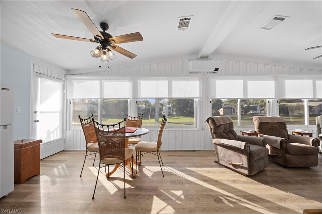 a dining room with furniture a chandelier and wooden floor