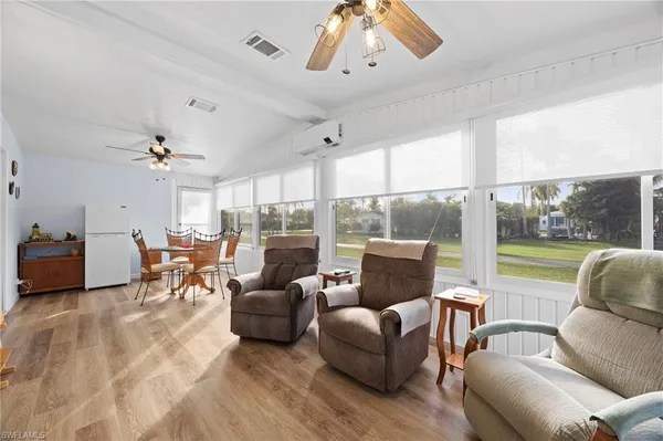 a living room with furniture ceiling fan and a floor to ceiling window