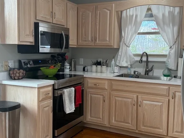a kitchen with stainless steel appliances granite countertop a stove a sink and a microwave