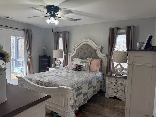 a bedroom with a bed a large window and dresser