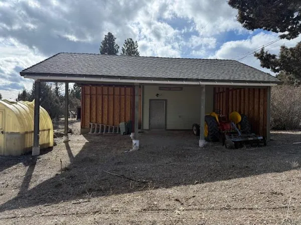 a backyard of a house with barbeque oven table and chairs