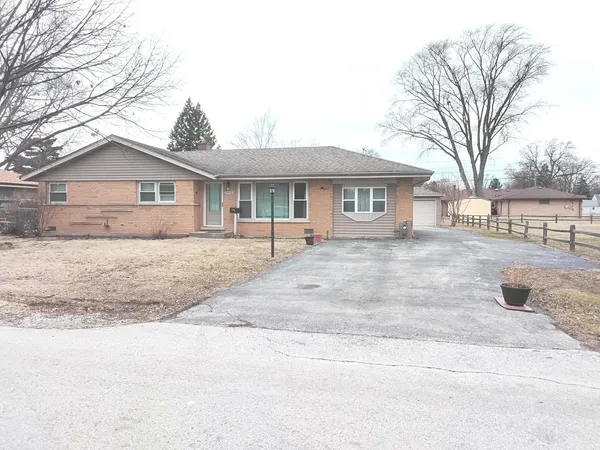 a front view of a house with a yard covered with snow