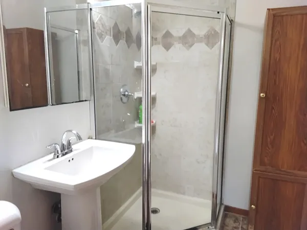a bathroom with a shower a sink and a mirror