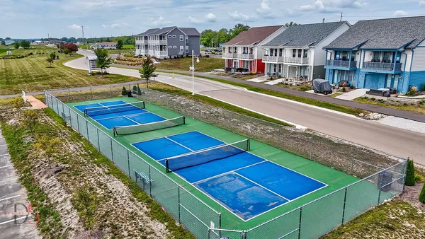 a view of a tennis ground with large trees
