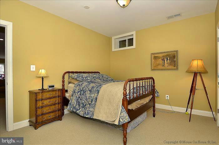 2801 Rifle Ridge Road Oakton, VA 22124 - Photo 5 of 30 a bed sitting in a bedroom next to a lamp