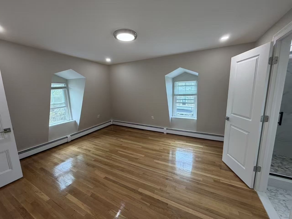 6 Channing Street, Unit 3 Newton, MA 02458 - Photo 1 of 12 an empty room with wooden floor and windows