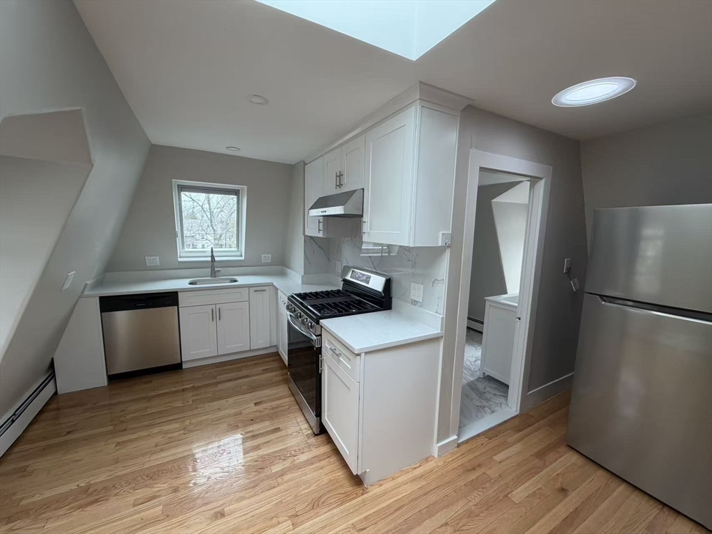 6 Channing Street, Unit 3 Newton, MA 02458 - Photo 2 of 12 a kitchen with a sink a refrigerator and a window