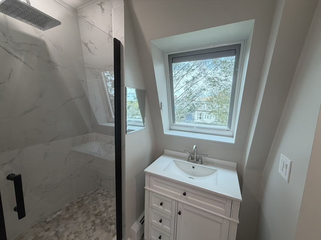 6 Channing Street, Unit 3 Newton, MA 02458 - Photo 9 of 12 a bathroom with a granite countertop sink a mirror and a shower