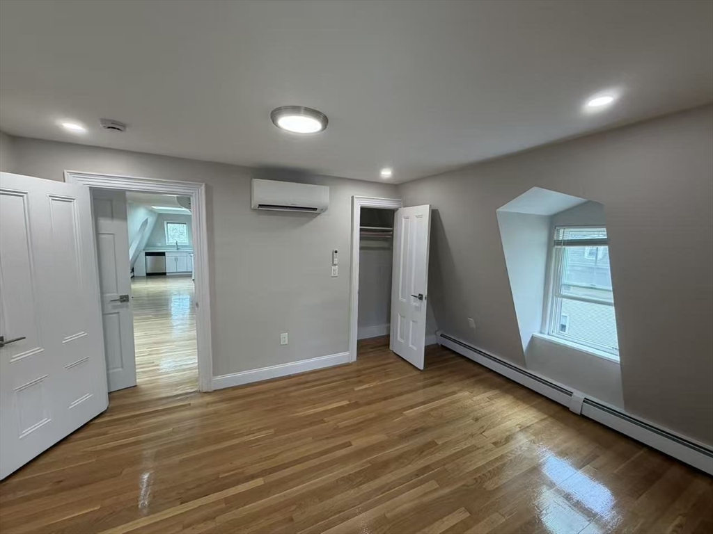 6 Channing Street, Unit 3 Newton, MA 02458 - Photo 10 of 12 an empty room with wooden floor and windows