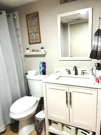 a bathroom with a sink a toilet and a mirror