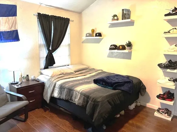 a bedroom with a bed and a painting on the wall