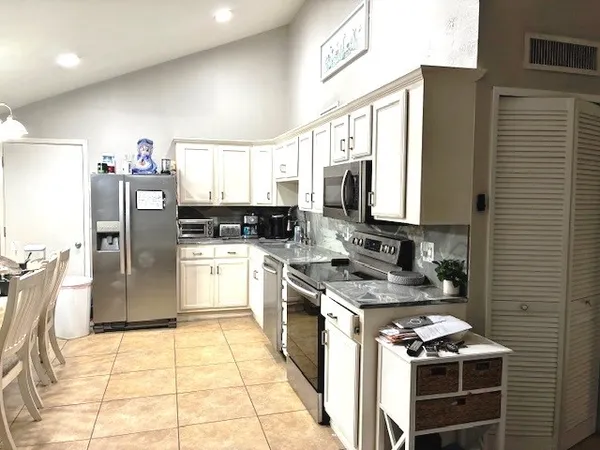 a kitchen with stainless steel appliances granite countertop a stove a sink dishwasher and a refrigerator