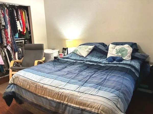 a bed sitting in a bedroom and chair