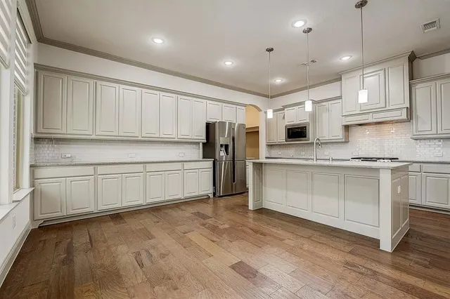 a kitchen with stainless steel appliances granite countertop a stove a sink and white cabinets
