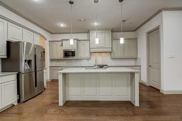 a kitchen with stainless steel appliances a refrigerator sink and microwave