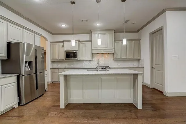 a kitchen with stainless steel appliances a refrigerator sink and microwave