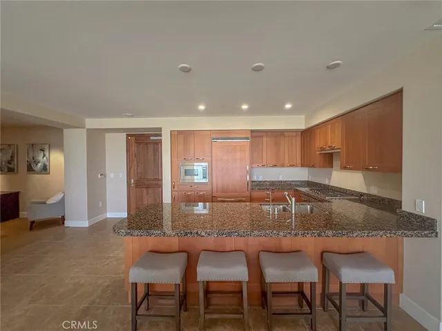 a kitchen with kitchen island a counter top space and stainless steel appliances