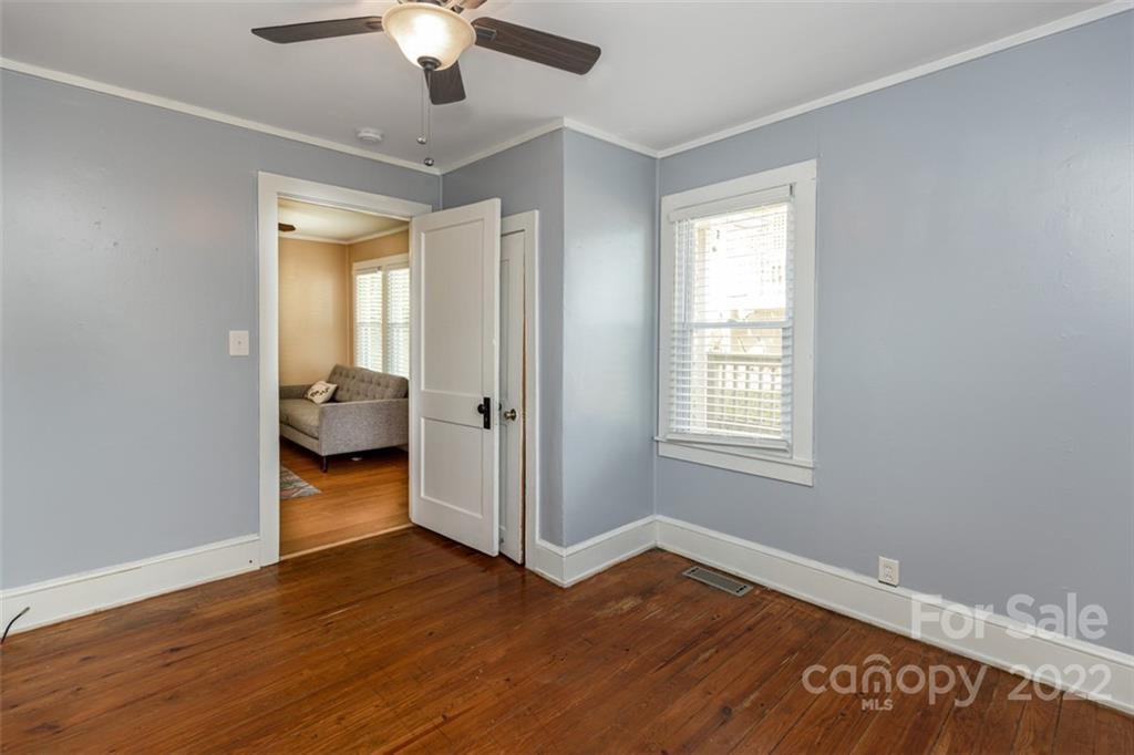 60 Shiloh Road Asheville, NC 28803 - Photo 8 of 13 a view of a room with wooden floor a chandelier fan and windows
