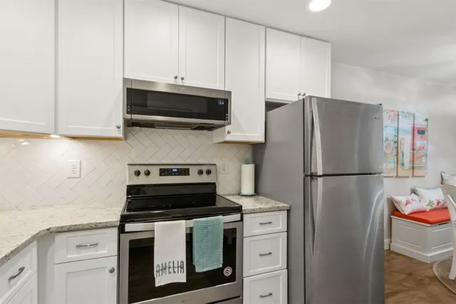 a kitchen with refrigerator a stove a microwave and cabinets