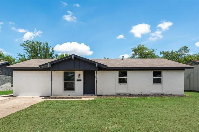 a front view of a house with a garden and yard