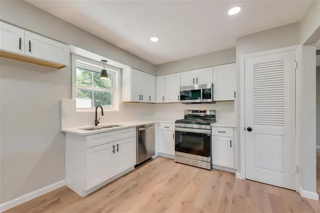 a kitchen with stainless steel appliances granite countertop a stove a sink and a refrigerator