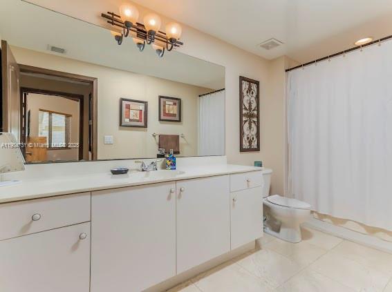 10700 Northwest 66th Street, Unit 508 Doral, FL 33178 - Photo 15 of 17 a bathroom with a double vanity sink and a toilet
