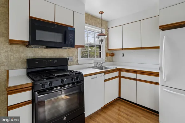 a kitchen with stainless steel appliances a stove microwave and sink