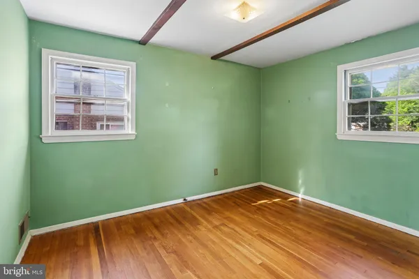 a view of a room with wooden floor and a window