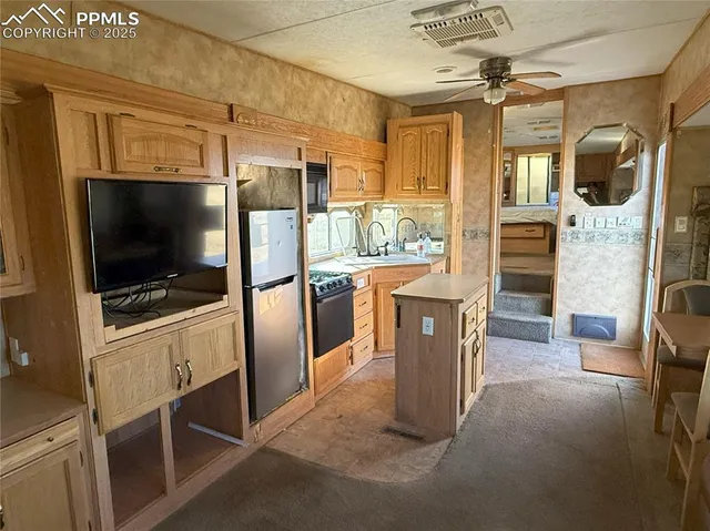 a kitchen with stainless steel appliances kitchen island granite countertop a refrigerator and a stove top oven