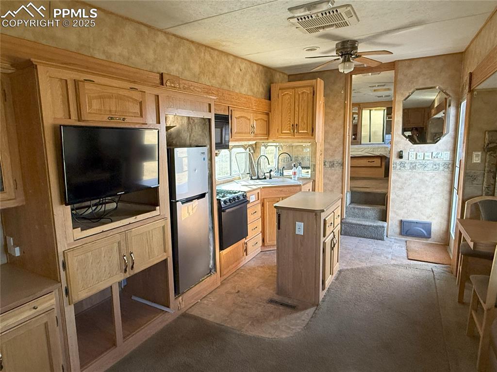 12325 Prairie Sun Point Colorado Springs, CO 80929 - Photo 12 of 15 a kitchen with stainless steel appliances kitchen island granite countertop a refrigerator and a stove top oven