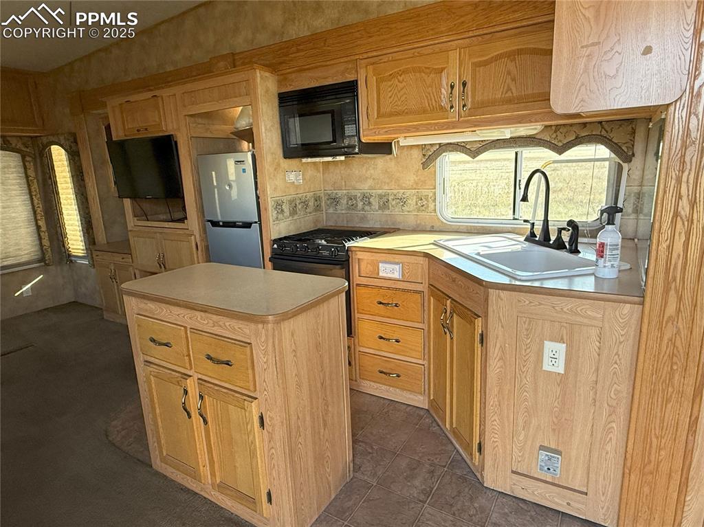 12325 Prairie Sun Point Colorado Springs, CO 80929 - Photo 9 of 15 a kitchen with stainless steel appliances granite countertop a sink stove and refrigerator
