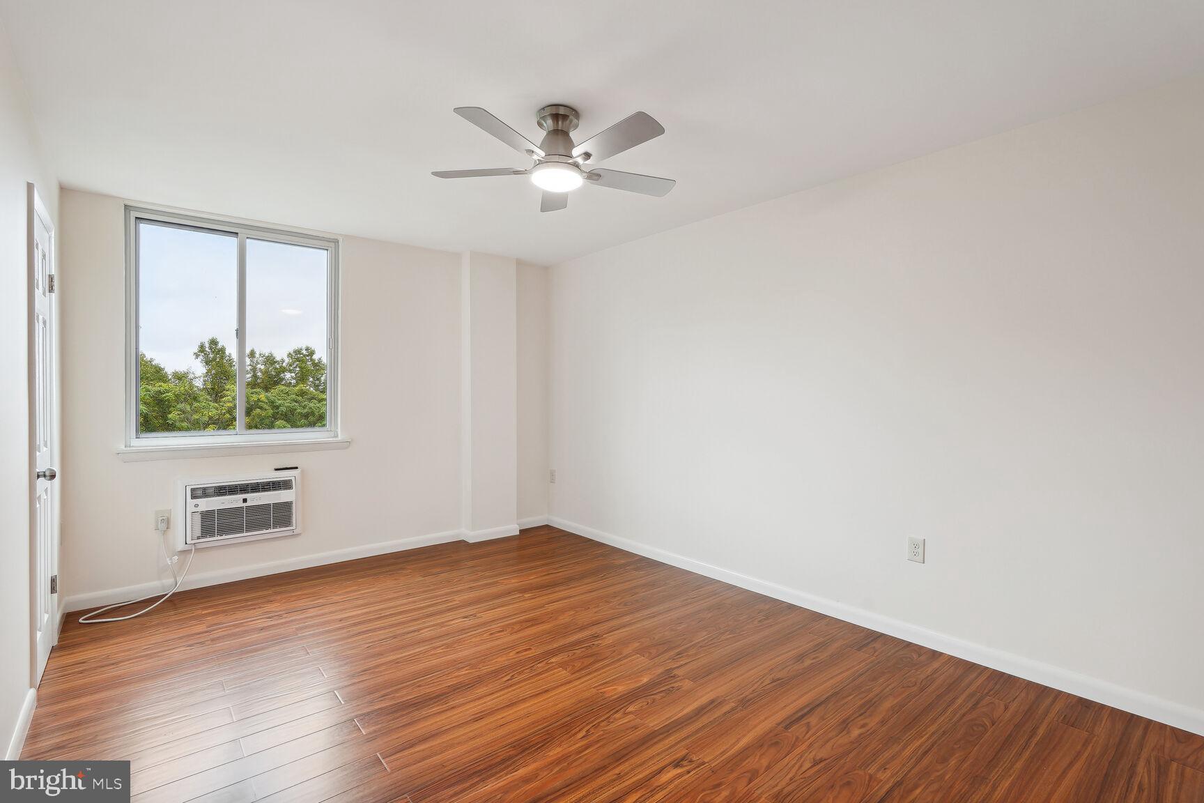 3245 Rio Drive, Unit 915 Falls Church, VA 22041 - Photo 17 of 31 an empty room with wooden floor fan and windows