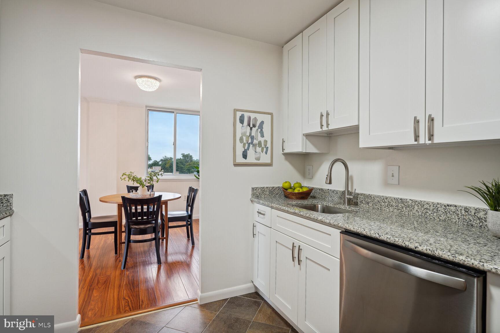 3245 Rio Drive, Unit 915 Falls Church, VA 22041 - Photo 9 of 31 a kitchen with stainless steel appliances granite countertop a table chairs sink and cabinets