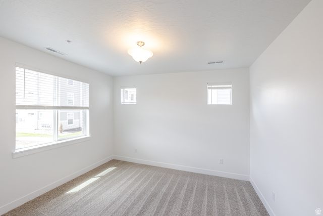 4695 South 690th West, Unit U101 Mapleton, UT 84664 - Photo 10 of 16 Bright interior space featuring light-toned walls and striped carpeting