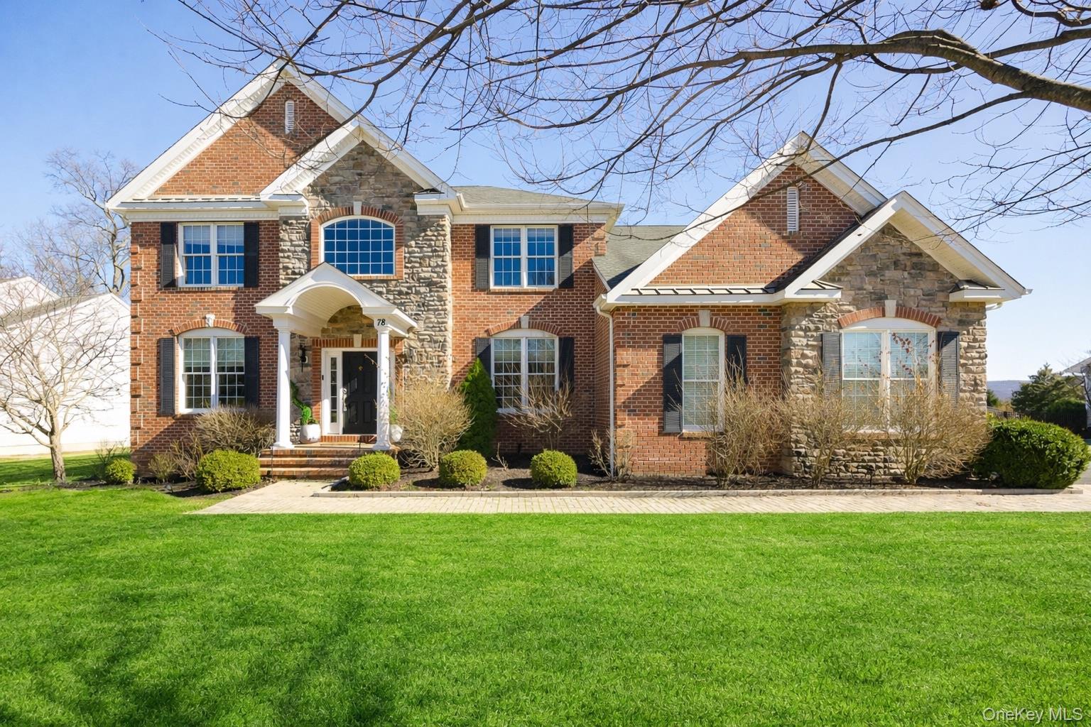a front view of a house with a yard and trees